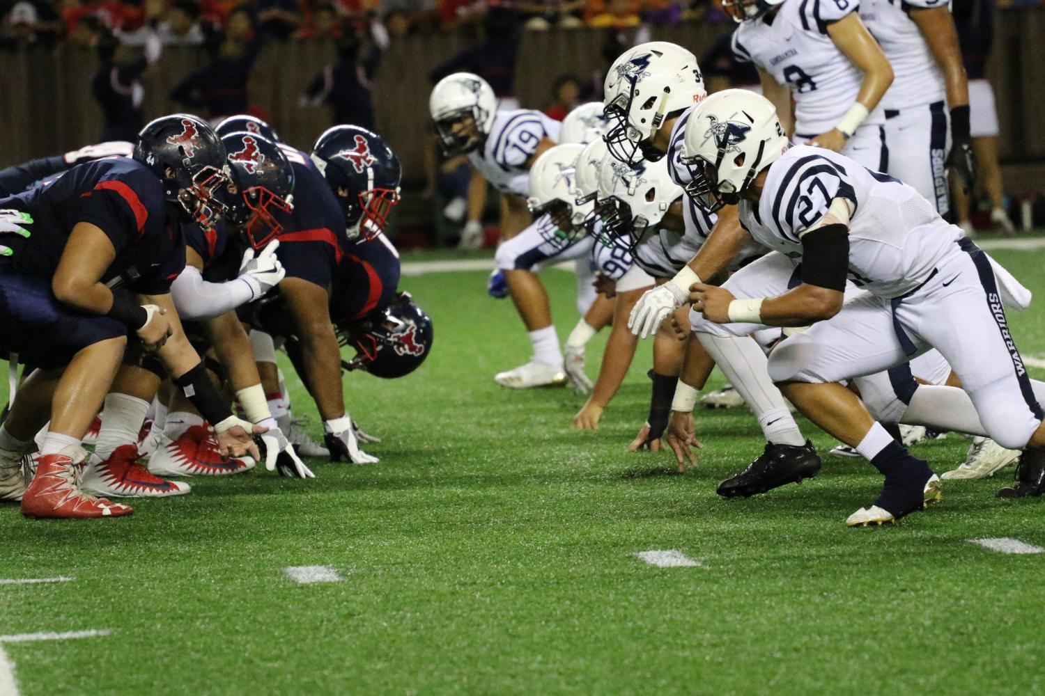 Desmond Unutoa (12th grade), alongside Warrior special teams, prepares for Saint Louis punt.