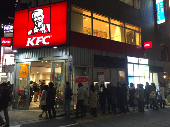 : Japanese individuals wait eagerly to get their hands on some “Christmas Chicken” from KFC.