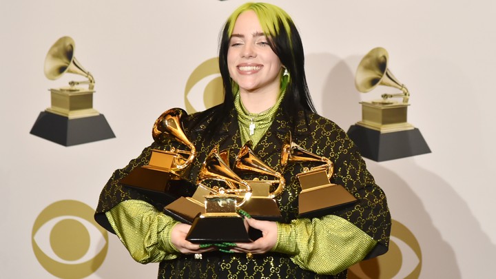 Billie Eilish proudly shows her five Grammy awards.