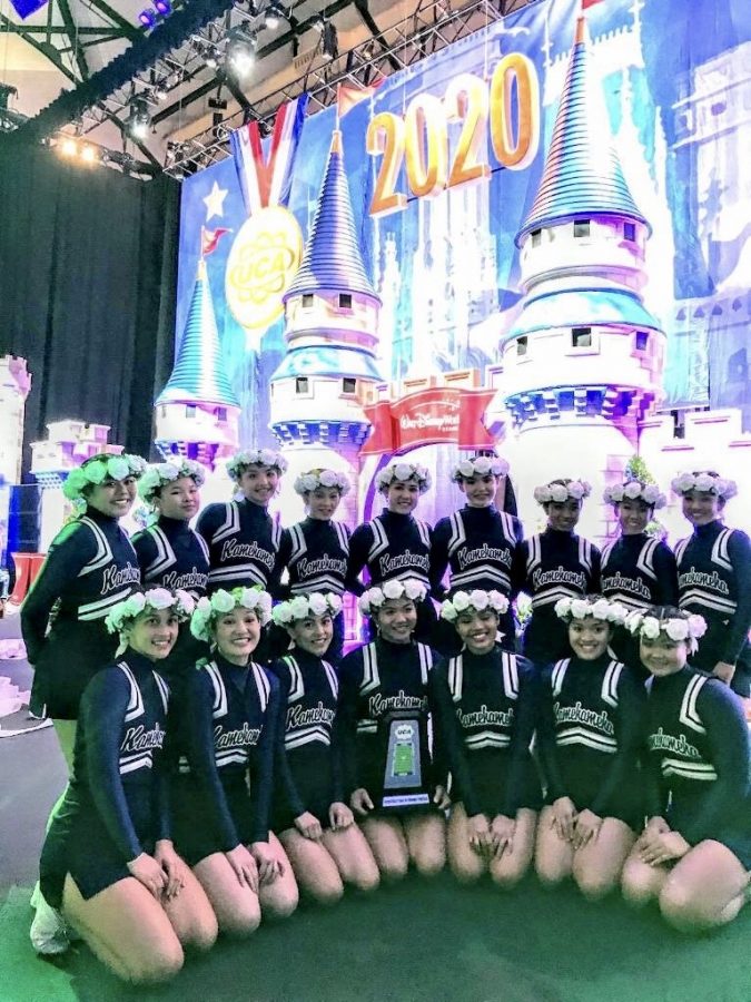 Here, is the varsity cheerleading team with their trophy in front of the finals competition castle. 