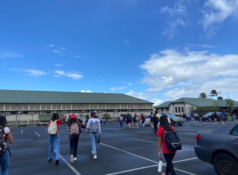 Students walk with one another to their classes with their masks on