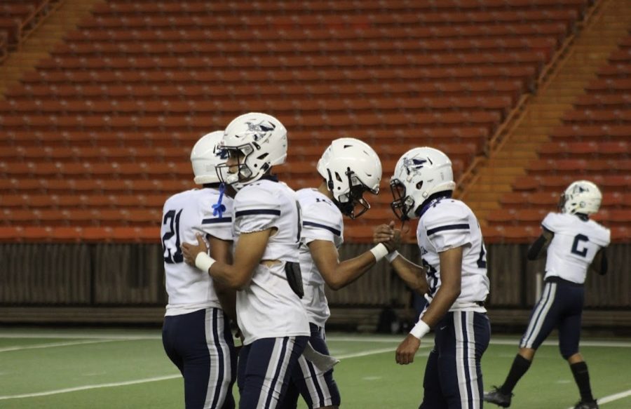 Teammates share a moment together before facing Punahou in
their first game