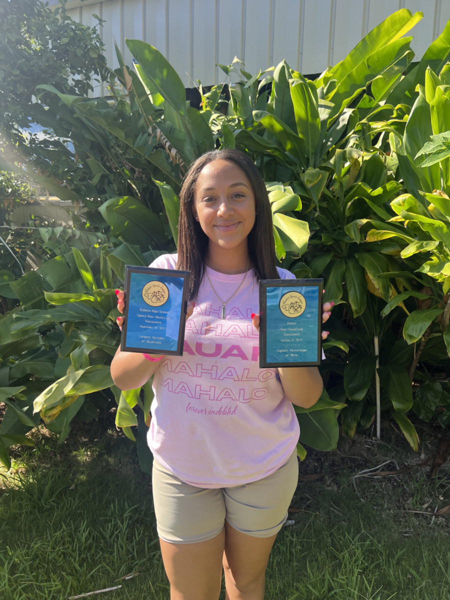 Vice President Addis Belay holds awards from the first Speech and Debate tournaments.